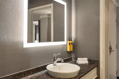 a bathroom with a sink and a mirror at Best Western Plus City Centre Centre-Ville in Quebec City