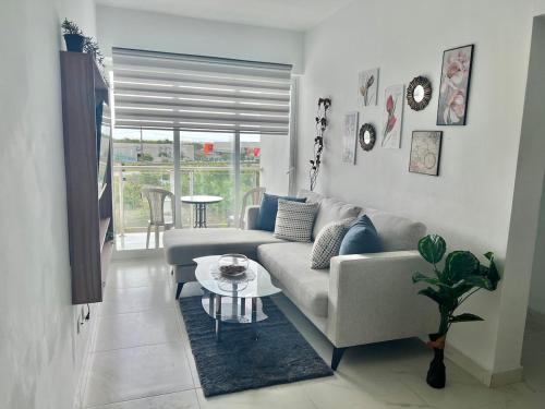 a living room with a couch and a table at Nice and Cozy Condo with Pool in Punta Cana