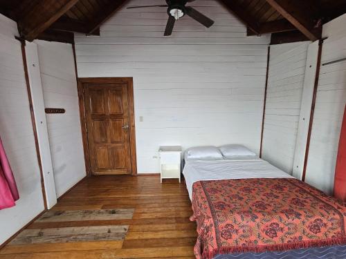 a bedroom with a bed and a wooden floor at Magnific Rock - Surf Resort & Yoga Retreat Nicaragua in Popoyo