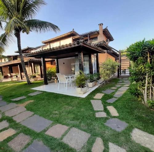 a house with a patio and a grass yard at Geribá Beach Apart Hotel casa 504 in Búzios