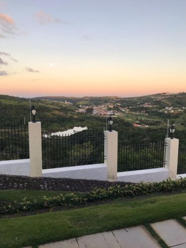 a white gate with a view of a city at Condomínio Serra Nevada - Chalé 202 in Bananeiras