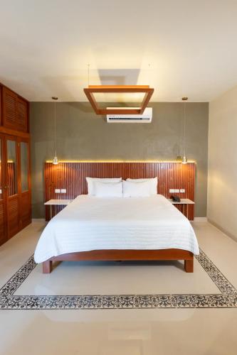 a bedroom with a large bed and a chandelier at Hotel Poquito a Poquito in Valladolid