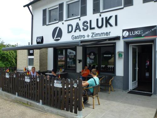 a restaurant with people sitting outside of it at Dasluki in Köngen