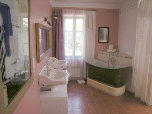 La salle de bains est pourvue d'une baignoire, de 2 lavabos et d'une baignoire. dans l'établissement Maison de Maitre Comfortable holiday residence, à Ferrals-lès-Corbières