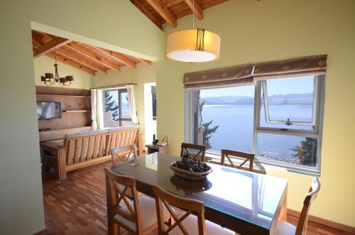 comedor con mesa y ventana grande en Balcones al Nahuel en San Carlos de Bariloche