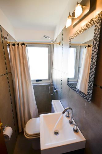 a bathroom with a sink and a toilet and a window at Balcones al Nahuel in San Carlos de Bariloche