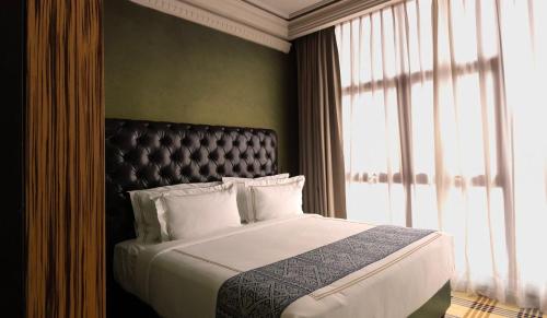 a bedroom with a large bed and a window at 1969 D'Kelly Hotel in Ipoh