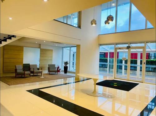 a lobby with a table and chairs and windows at Luxury Studio - Aeroporto GRU in Guarulhos