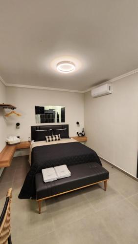 a bedroom with a large bed with two towels on it at ANGATU CHALÉS Bem Estar, Aconchego e Conforto in Serra Negra