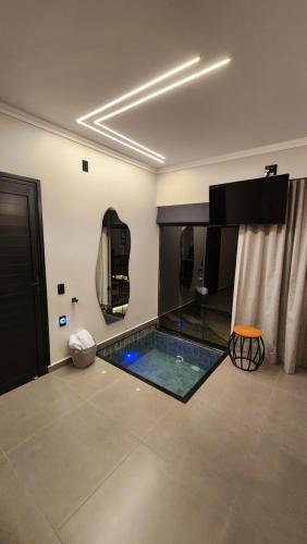 a room with a swimming pool in the middle of a room at ANGATU CHALÉS Bem Estar, Aconchego e Conforto in Serra Negra