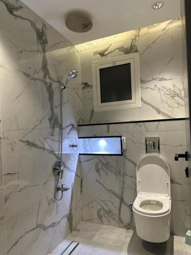 a bathroom with a toilet and a tv on the wall at Home apartment 2 in Medina