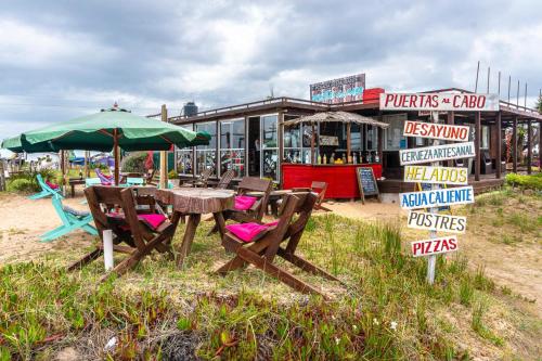 a picnic table and umbrella in front of a store at Puertas al Cabo in Cabo Polonio