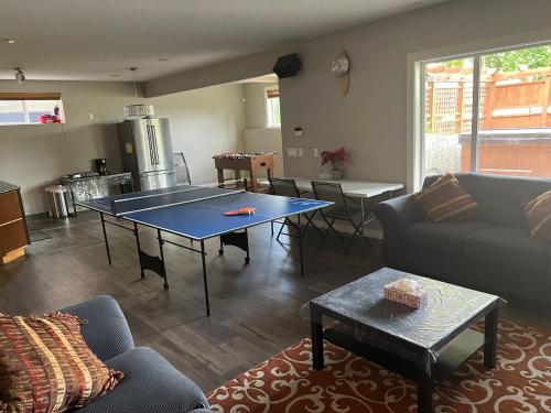 Una sala de estar con una mesa de ping pong. en Rooms for Hosting, en Calgary