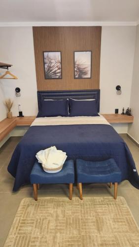 a large blue bed with a blue comforter at ANGATU CHALÉS Bem Estar, Aconchego e Conforto in Serra Negra