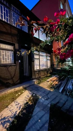 a house with a door and a fence and flowers at Hotel Cápsula Bogotá Castellana in Bogotá