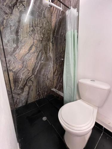 a bathroom with a toilet and a shower at Hotel Cápsula Bogotá Castellana in Bogotá
