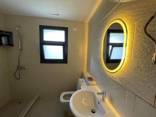a bathroom with a sink and a toilet and a mirror at Gaia - Ras Elhekma- Notth coast in Zāwiyat al ‘Awwāmah