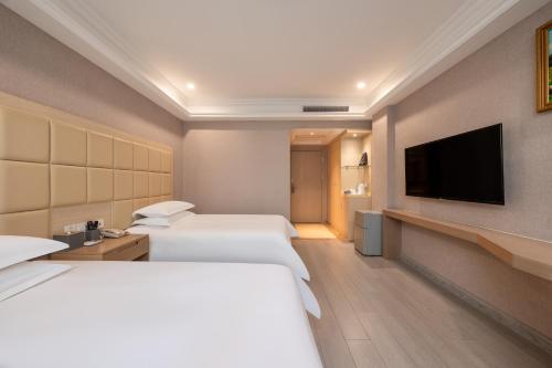a hotel room with two beds and a flat screen tv at Rezen Select Shanghai International Resort in Shanghai