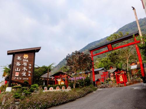a street in front of a village with a red gate at Melon Shan Spa World in Liugui