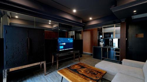 a living room with a tv and a couch and a table at 1969 D'Kelly Hotel in Ipoh
