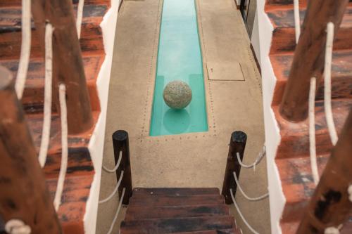 a swimming pool with a rock in the water at Ade Hotel Bacalar in Bacalar