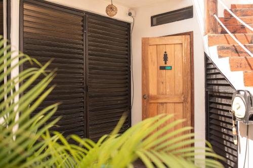 a house with a wooden door and a plant at Ade Hotel Bacalar in Bacalar