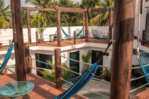 a deck with chairs and tables on a building at Ade Hotel Bacalar in Bacalar
