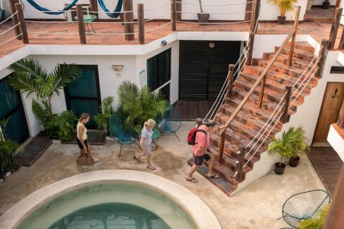 a group of people walking around a swimming pool at Ade Hotel Bacalar in Bacalar