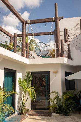 a house with a balcony with chairs and plants at Ade Hotel Bacalar in Bacalar