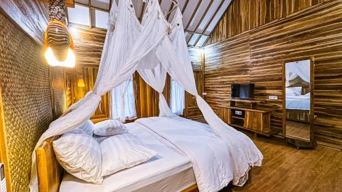 a bedroom with a bed with a mosquito net at Dunya Villa in Gili Islands