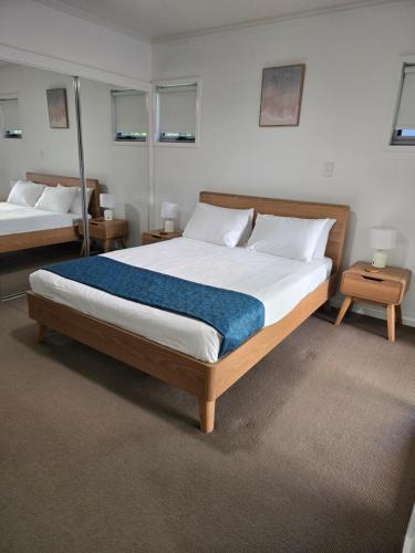 a bedroom with two beds and two tables at Quarterdecks Retreat in Hervey Bay