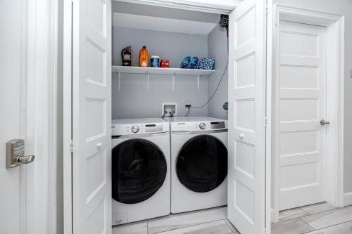 a white laundry room with a washer and dryer at NEW! Palm Harbor Hideaway - Beautiful, Spacious 4BR Home with Amazing Pool in Palm Harbor