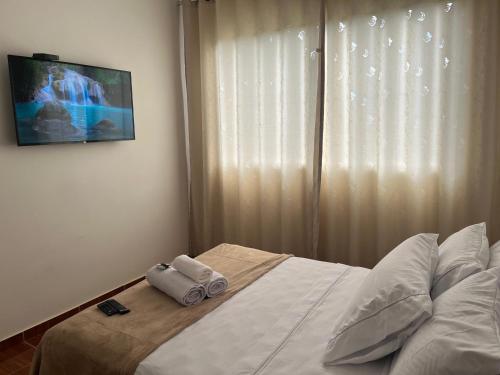 a bedroom with a bed with two towels on it at Pousada Rio Cipó in Serra do Cipo