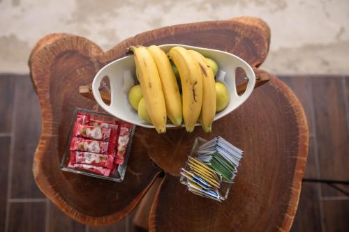a bowl of bananas and fruit on a wooden table at Ade Hotel Bacalar in Bacalar