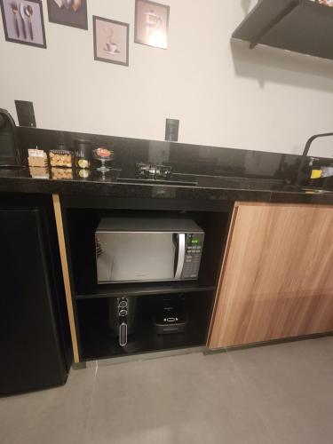a tv in a counter in a room at ANGATU CHALÉS Bem Estar, Aconchego e Conforto in Serra Negra