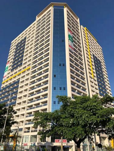 a tall building with a tree in front of it at Studio Luxo Próx Aeroporto GRU in Guarulhos