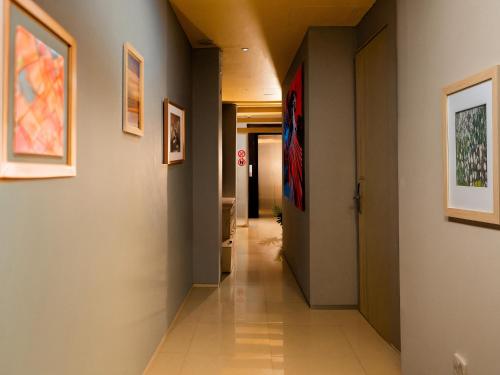 a hallway in a building with paintings on the walls at Kuta Cube Hostel in Kuta