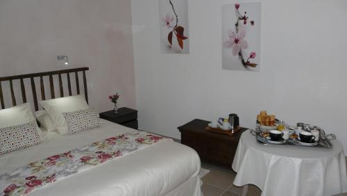 a bedroom with a bed and a table with dishes on it at Domaine de Janis & Spa in Le Vigan