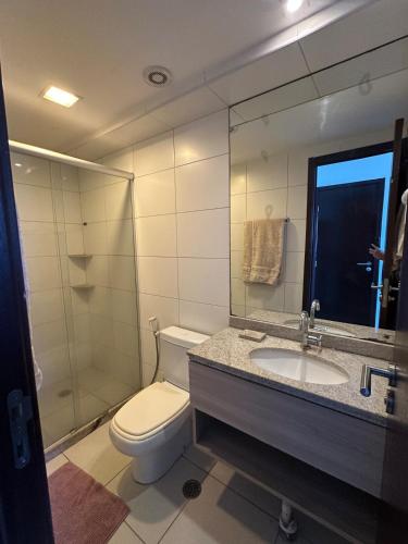 a bathroom with a toilet and a sink and a mirror at Flat Prime 2 quartos Hotel Boa viagem in Recife