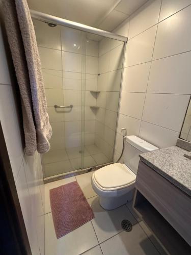 a bathroom with a toilet and a glass shower at Flat Prime 2 quartos Hotel Boa viagem in Recife
