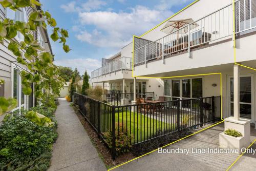 a house with a black fence and a balcony at Cosy Inner City Apartment with Free Parking in Christchurch