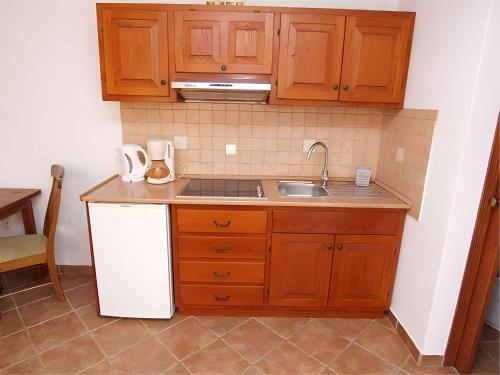 a kitchen with wooden cabinets and a sink at Apartment in Veli Losinj 14995 in Veli Lošinj