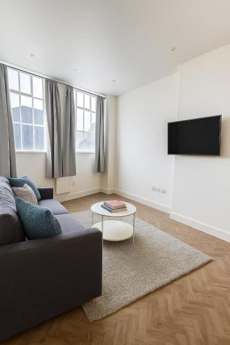 a living room with a couch and a tv at Bright & Cozy in Chelmsford in Chelmsford