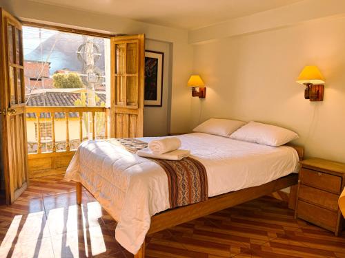 a bedroom with a bed and a large window at Nafis Casona Apu Linli Pisac in Pisac