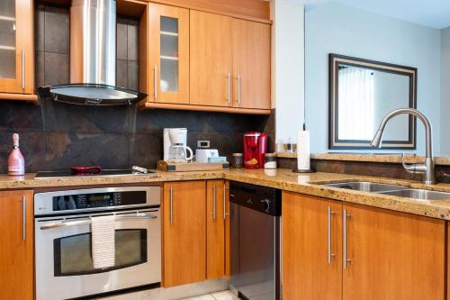 a kitchen with wooden cabinets and a sink at Luxury Beach Front Condo Balcony Pool and Jacuzzi in Buena Vista