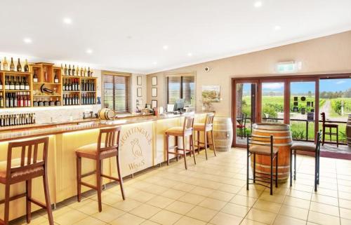 a kitchen with a bar with bar stools at Nightingale Villas in Broke