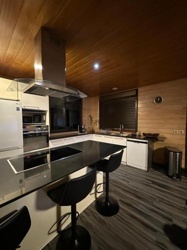 a kitchen with a counter and some stools in it at Inake Lodge in Atuona