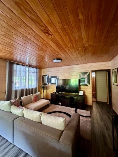 a living room with a couch and a television at Inake Lodge in Atuona