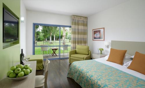a bedroom with a bed and a living room at Nof Ginosar Kibbutz Hotel in Kibbutz Ginnosar