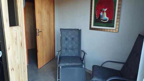 a chair in a room next to a door at Casa Shalom 2 Room App! Internet! Parking! Sauna! Quiet! Central! Esperanza village! in Hohenau